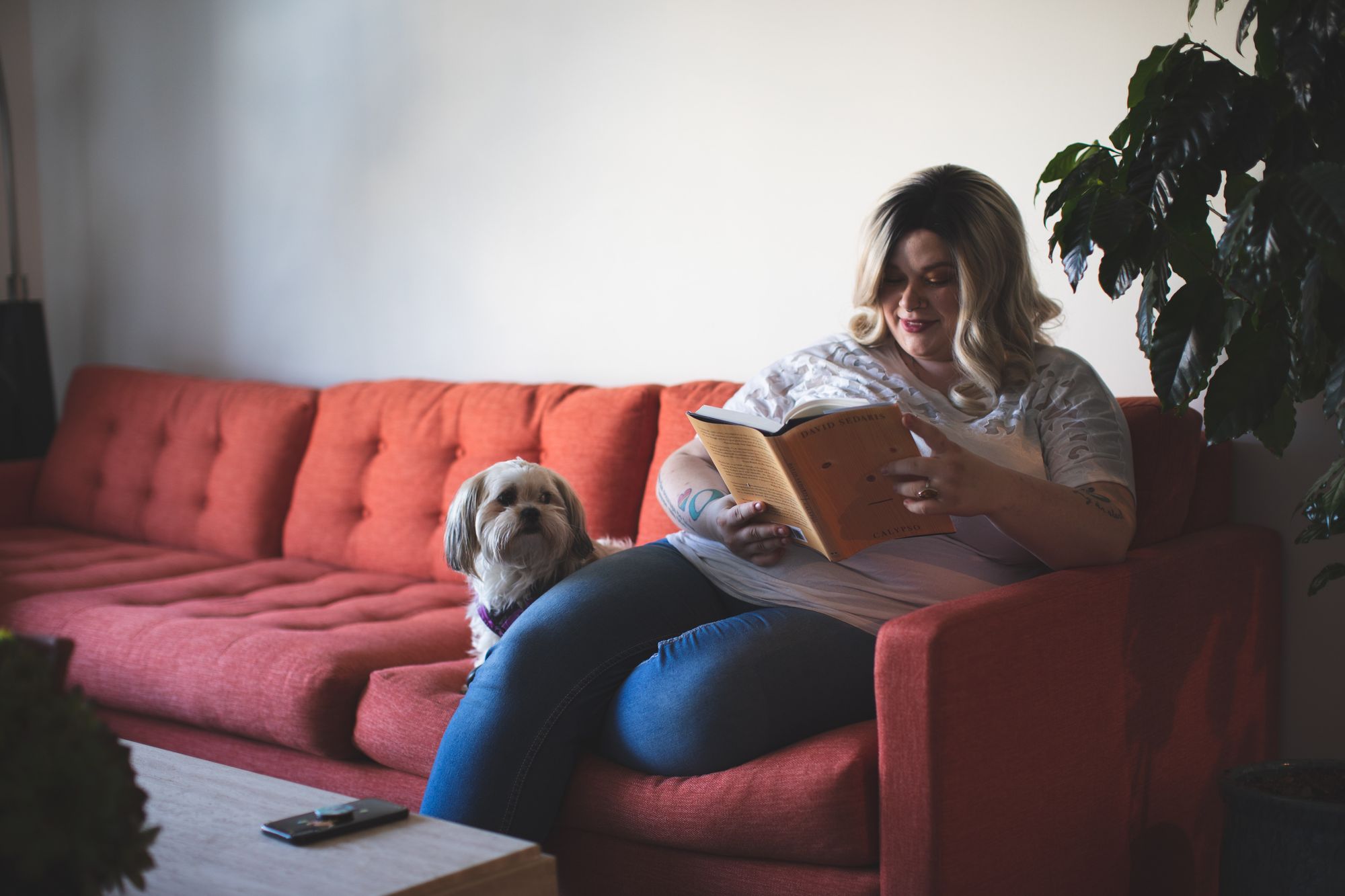 woman-and-dog-cozy-on-red-sofa